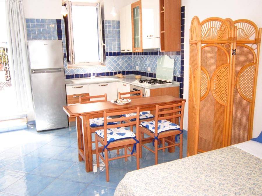 a kitchen with a table and chairs and a refrigerator at Le Case dei Pescatori - La Suite in Ponza