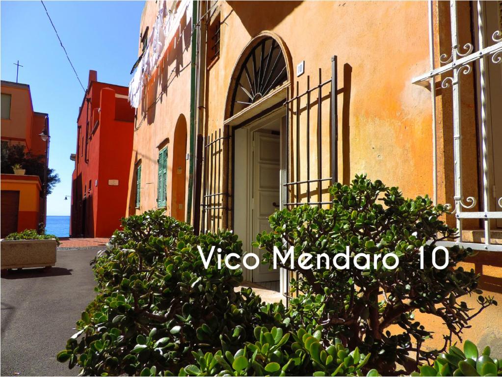 un edificio con una porta e cespugli di fronte di Le Casasse "Vico Mendaro 10" a Varigotti