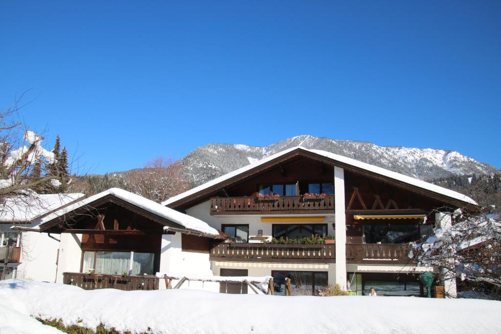 ein großes Gebäude mit Balkon im Schnee in der Unterkunft Alpen - Apartments in Garmisch-Partenkirchen