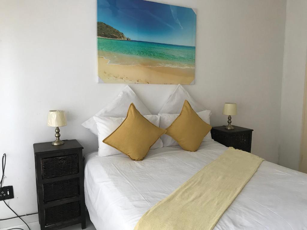 a bedroom with a white bed with yellow pillows at Lala’s guest house in Johannesburg