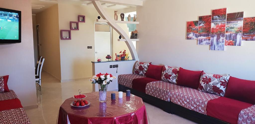 sala de estar con sofá rojo y mesa en Appartement de luxe centre ville les "Dunes d'Or", en Oujda