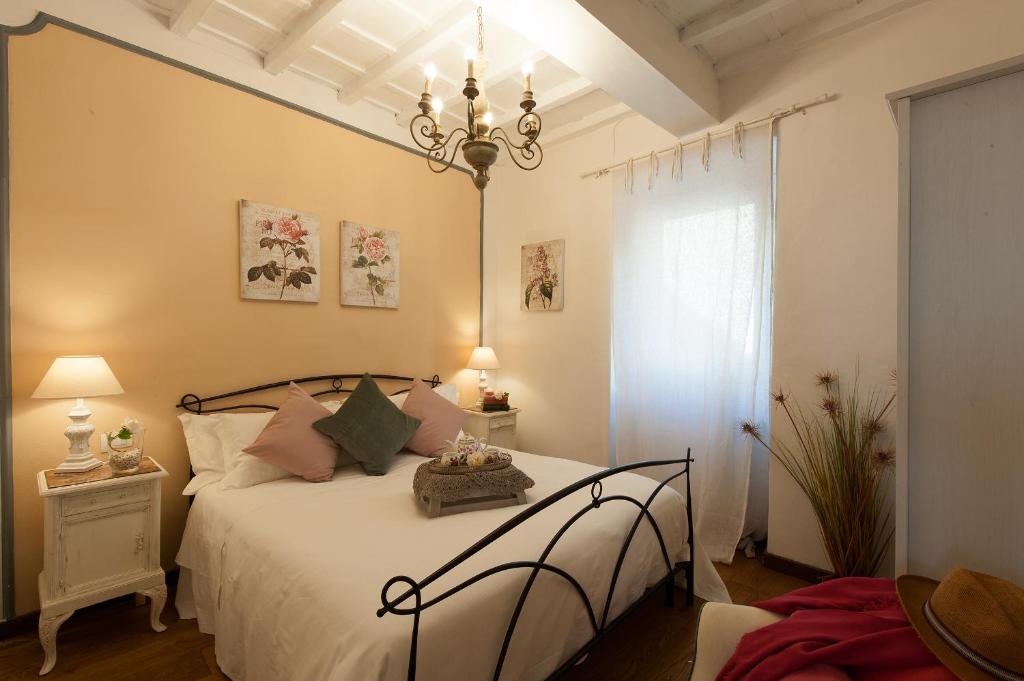 フィレンツェにあるBelvedere Suite Florenceのベッドルーム1室(白いシーツとシャンデリア付)