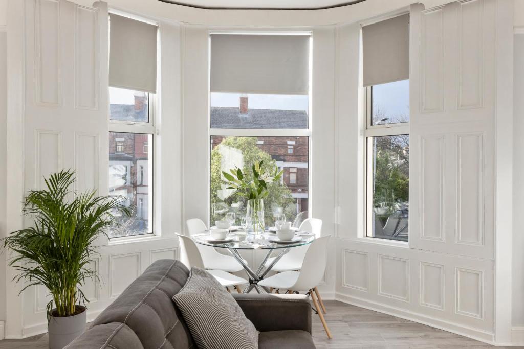 un soggiorno con tavolo, sedie e finestre di Cyprus View Apartment 2 a Belfast