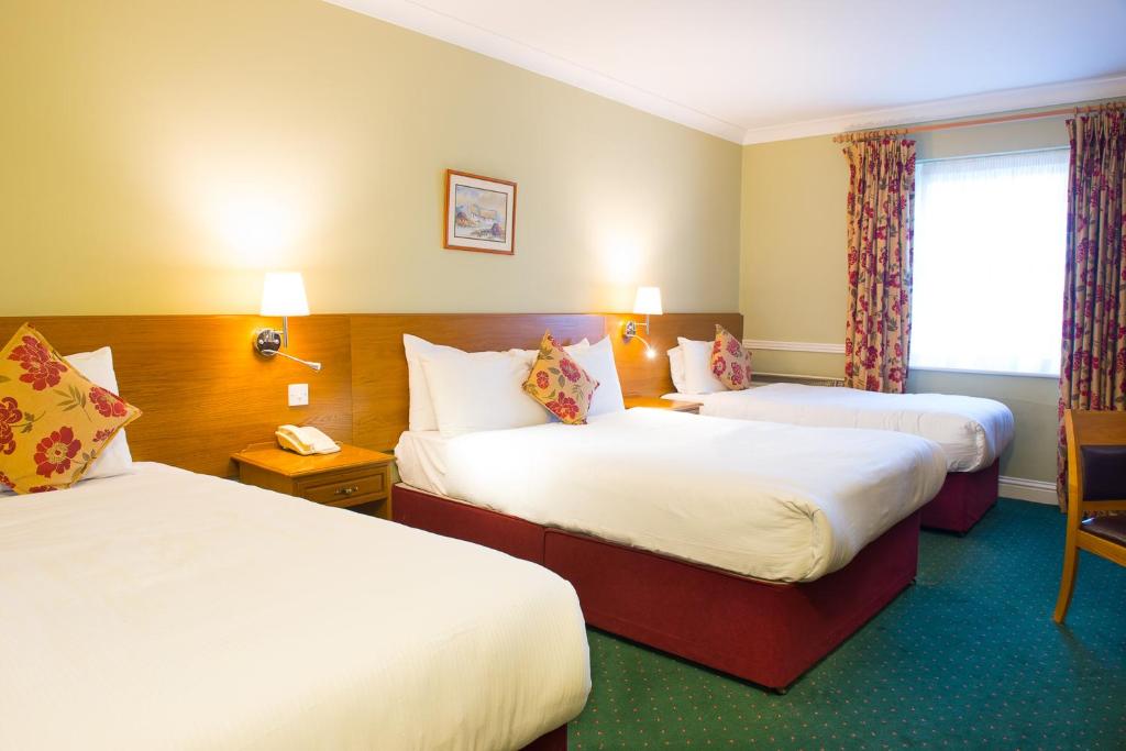 Postel nebo postele na pokoji v ubytování Tralee Benners Hotel