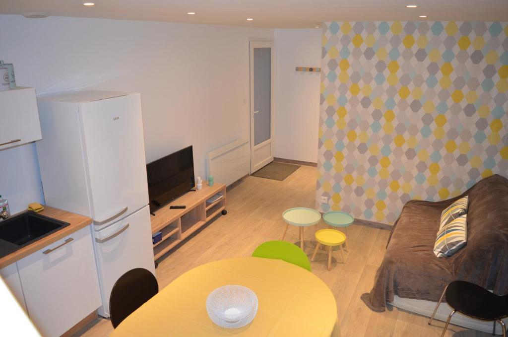 a living room with a couch and a table at Logement Vendée in Saligny