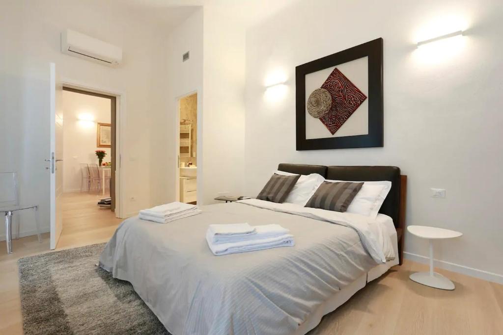 a bedroom with a large bed with towels on it at Opera 19 Luxury Apartment in Florence
