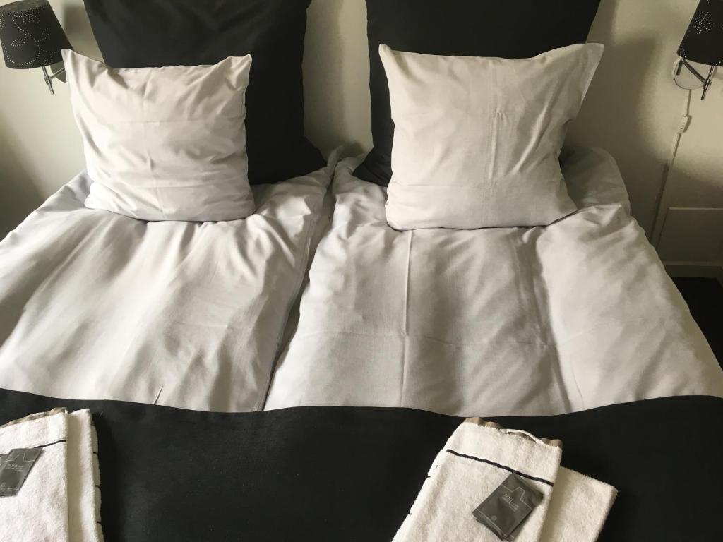 een bed met witte lakens en kussens bij Hotel Rødding in Rødding