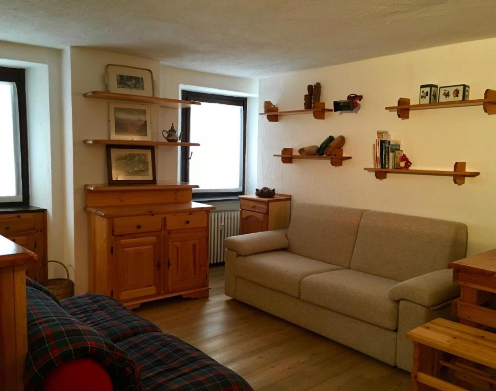 een woonkamer met een bank en een raam bij Casa Grangeon in La Thuile