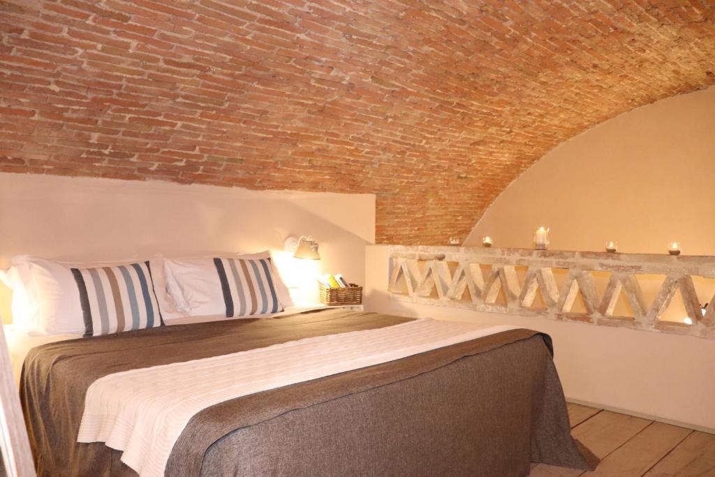 a bedroom with a bed with a brick wall at Borgo San Gaetano in Bernalda