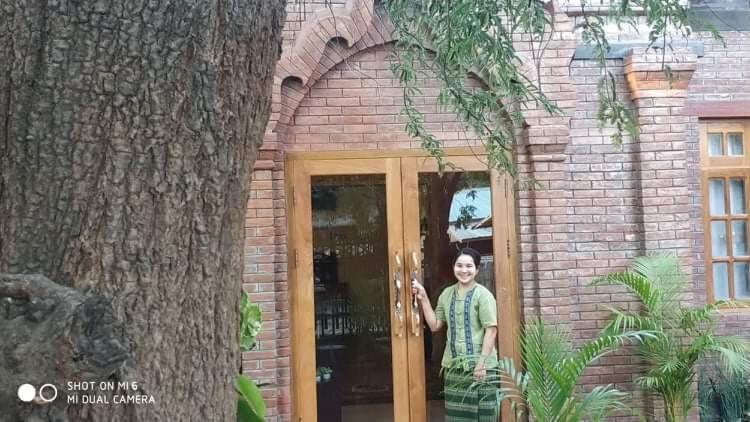 a woman standing in the doorway of a brick building at Look Myanmar in Bagan
