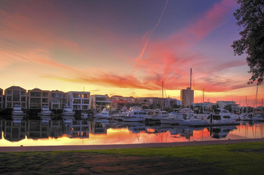 un puerto deportivo al atardecer con barcos en el agua en Haven Marina Motel, en Adelaida