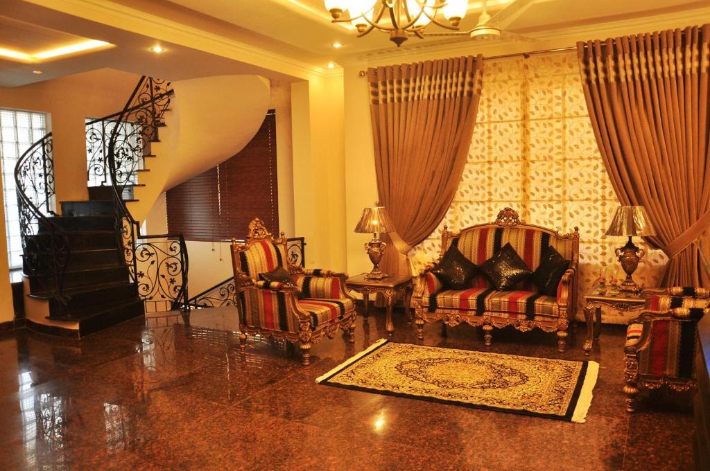 a living room with two chairs and a couch at Reina Boutique Hotel - G9 in Islamabad