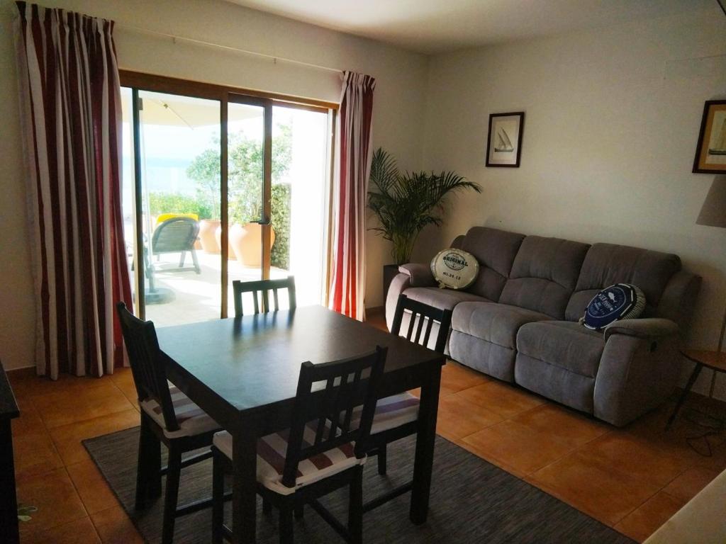 a living room with a table and a couch at Ribalta Beach Houses in Ericeira