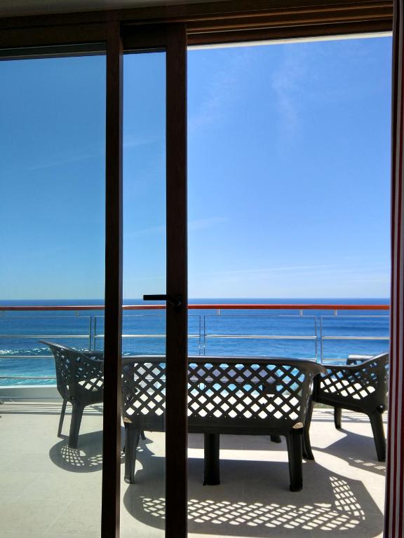 a view of the ocean from a room with sliding glass doors at Ribalta Beach Houses in Ericeira
