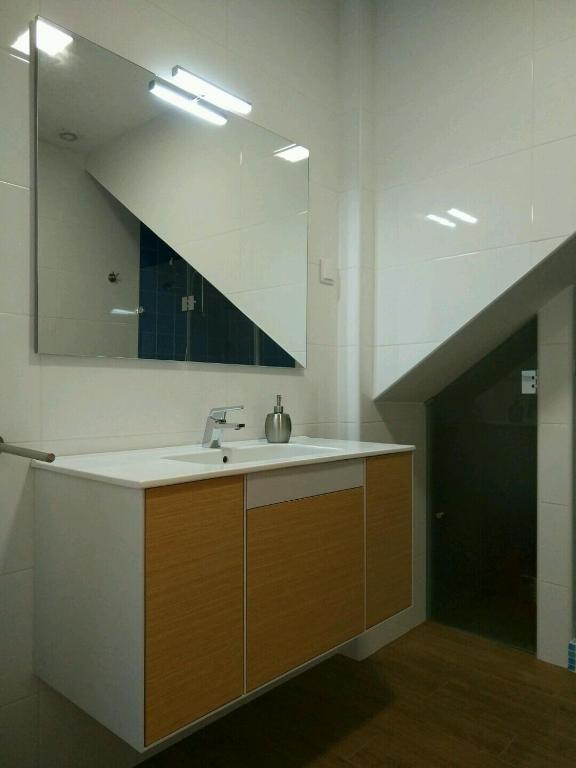 a bathroom with a sink and a large mirror at Ribalta Beach Houses in Ericeira