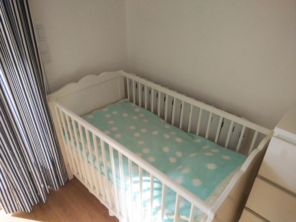 a white crib with a blue and white cribsheet at Ribalta Beach Houses in Ericeira