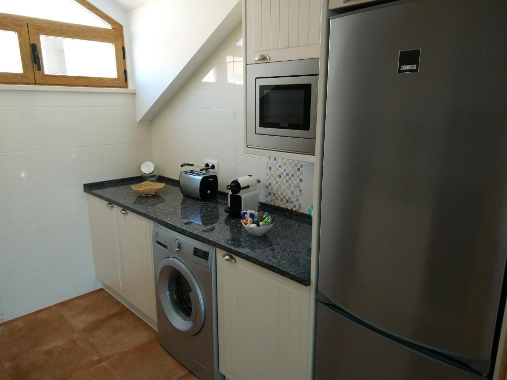 a kitchen with a refrigerator and a washing machine at Ribalta Beach Houses in Ericeira