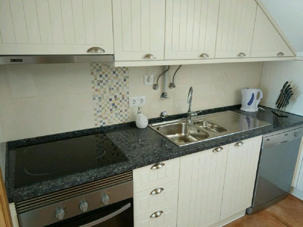a kitchen with a sink and a counter top at Ribalta Beach Houses in Ericeira