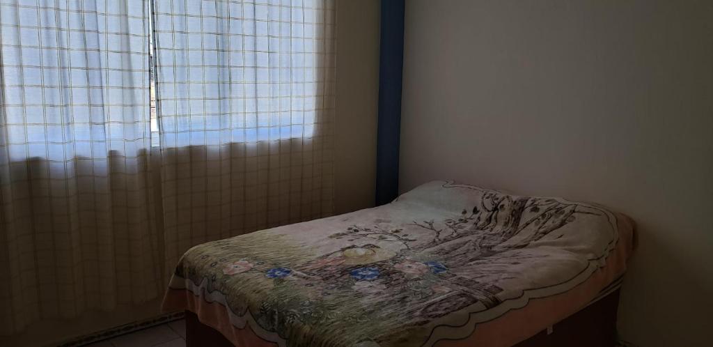 a small bed in a room with a window at Hotel Anturio in Huajuapan de León