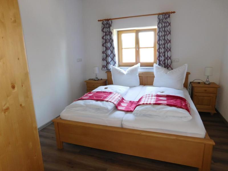 a bedroom with a large bed with a window at Ferienwohnung Linder in Hopferau