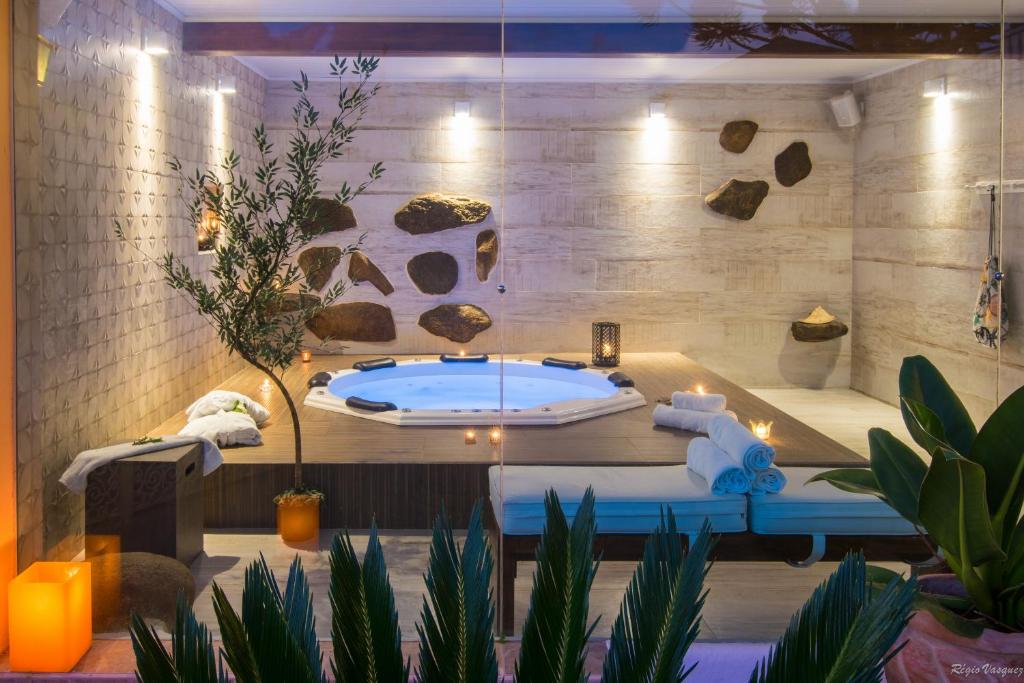uma casa de banho com banheira num quarto com plantas em Pousada Ricanto Amore Mio em Monte Verde