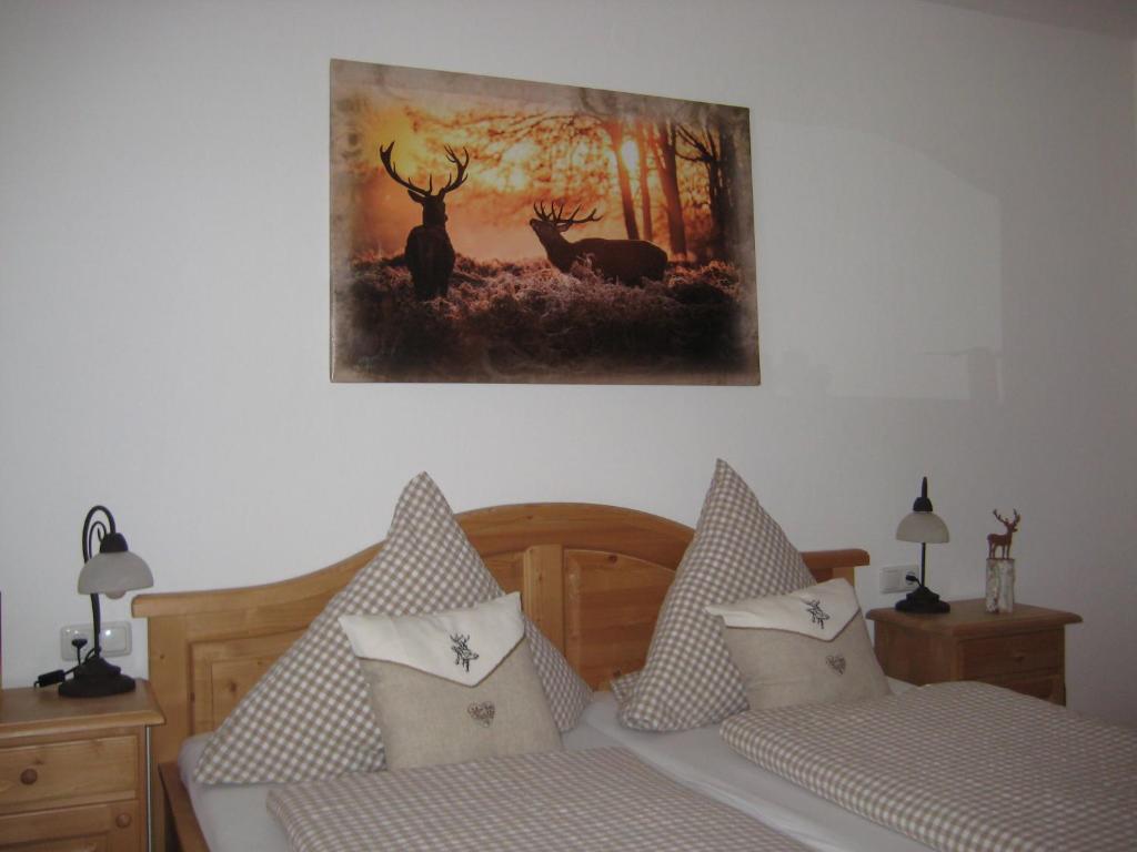 a bedroom with two beds and a painting on the wall at Landhotel zum Staffelwirt in Jachenau