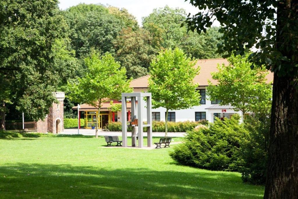 a park with a bench in front of a building at Kim Hotel Im Park in Dresden