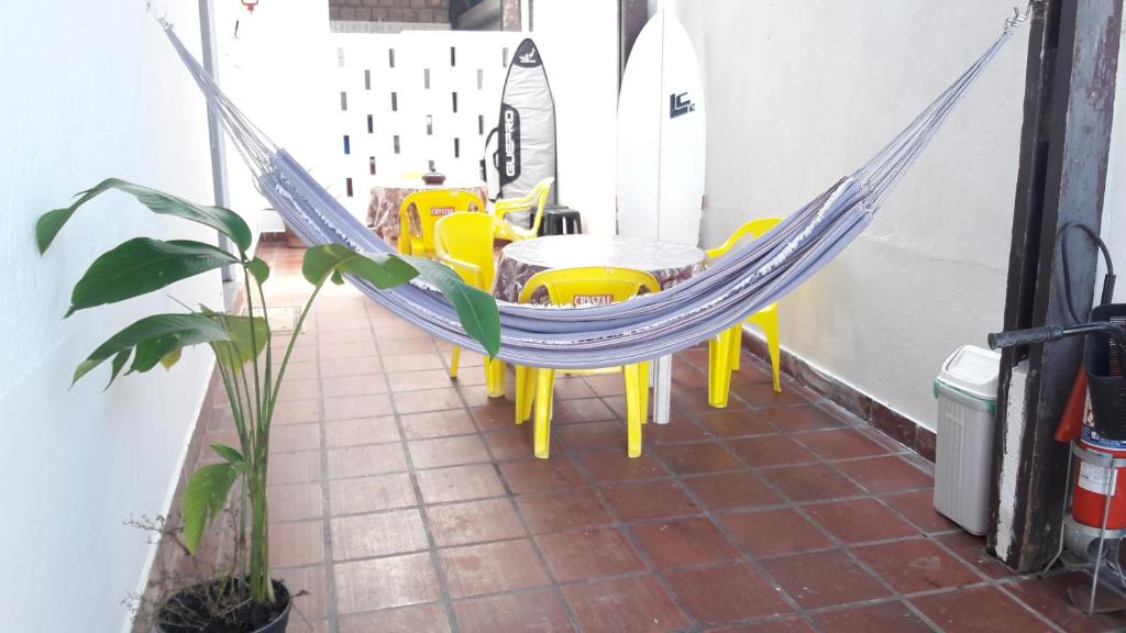 - un hamac sur un balcon avec une table et des chaises dans l'établissement Guarujá A Casa do O Tio, à Guarujá