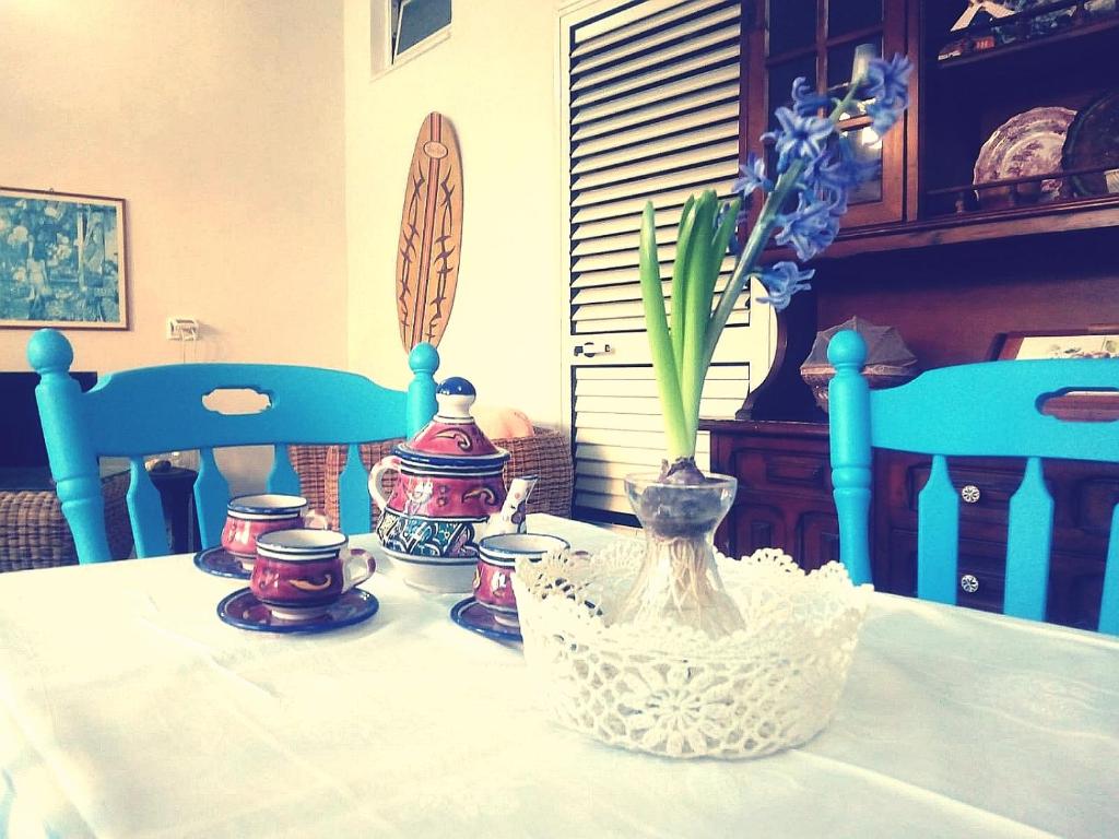 une table avec un vase avec des fleurs. dans l'établissement casadellestelle34, à Mazara del Vallo