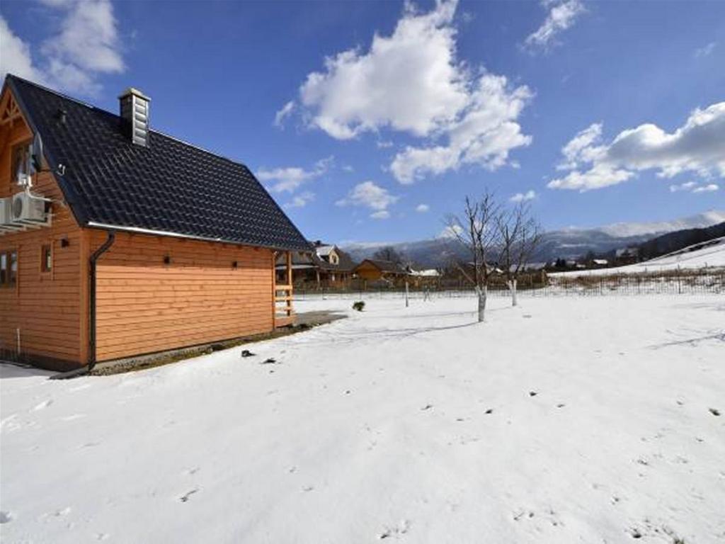 a building in a field with snow on the ground at Miłe Zacisze in Karpacz