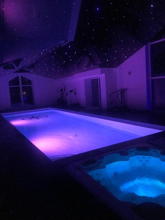 a swimming pool with purple lights in a room at Browns in Peterhead