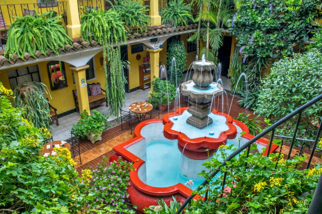 - un jardin avec une fontaine au milieu d'un bâtiment dans l'établissement Posada San Vicente by AHS, à Antigua Guatemala