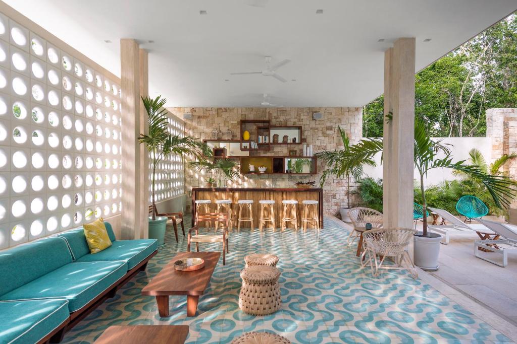 a living room with a blue couch and a table at Hotel Tiki Tiki Tulum in Tulum