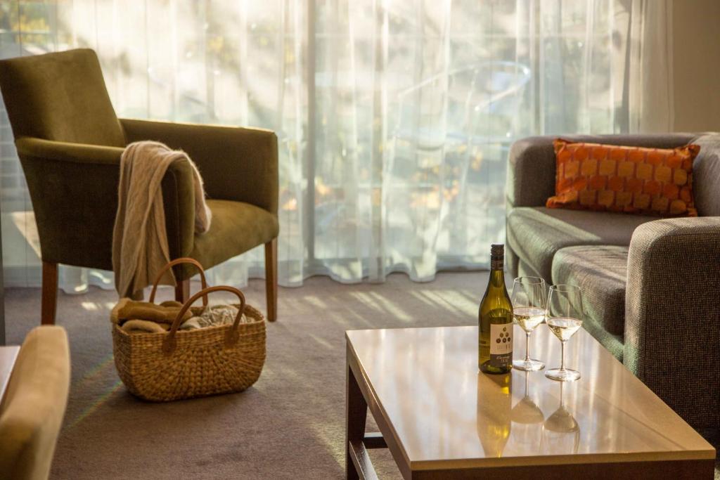 a living room with a bottle of wine and a table at The Sebel Launceston in Launceston