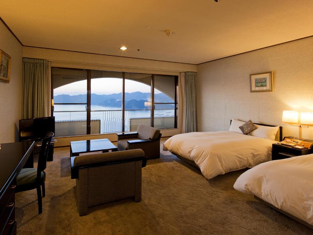 um quarto de hotel com duas camas e uma grande janela em Plaza Awajishima em Minamiawaji