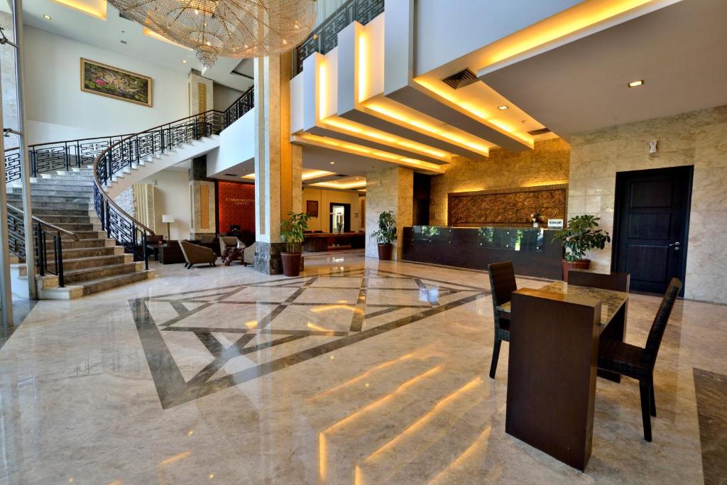 a lobby with a staircase and a table and chairs at Gino Feruci Kebon Jati by KAGUM Hotels in Bandung