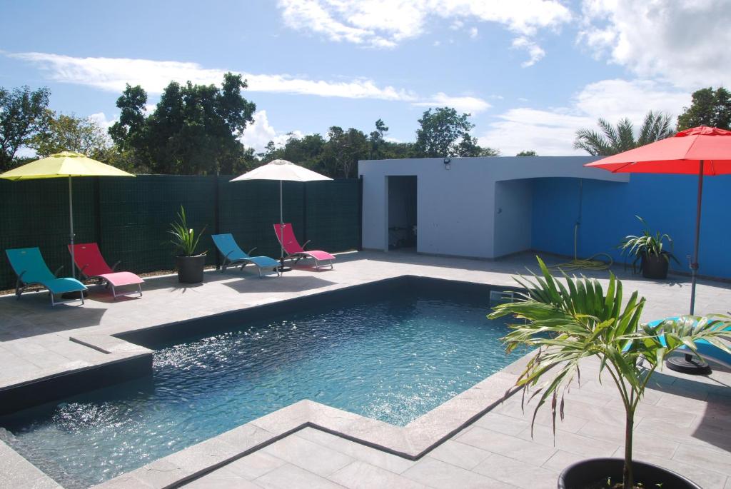 einen Pool mit Stühlen und Sonnenschirmen auf einer Terrasse in der Unterkunft Villa Un Jour, Un Rêve in Chassaing