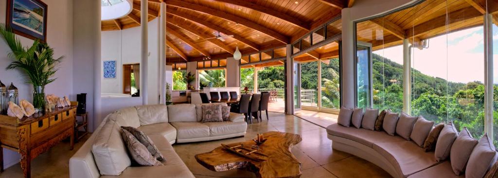 un grand salon avec des canapés et une salle à manger dans l'établissement Villa Maria, à Rarotonga