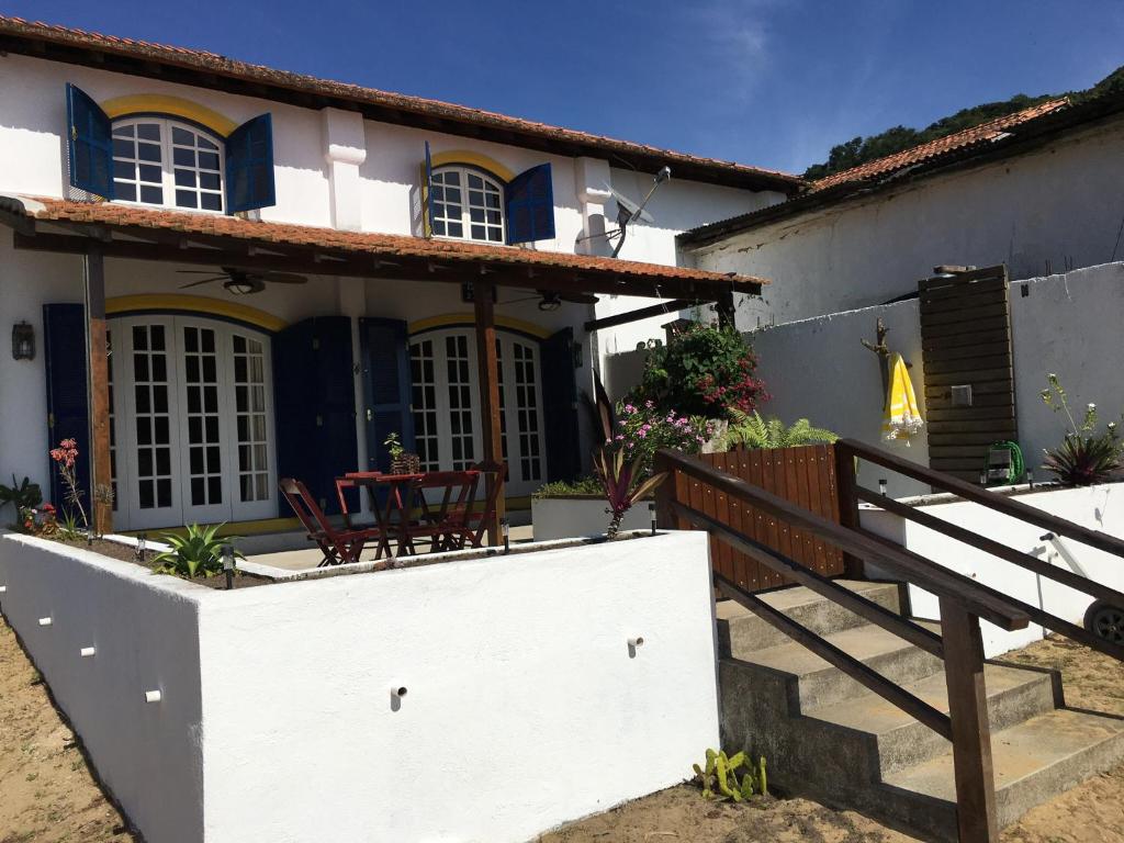 a house with a table and chairs in front of it at Casarao da Praia in Praia Vermelha