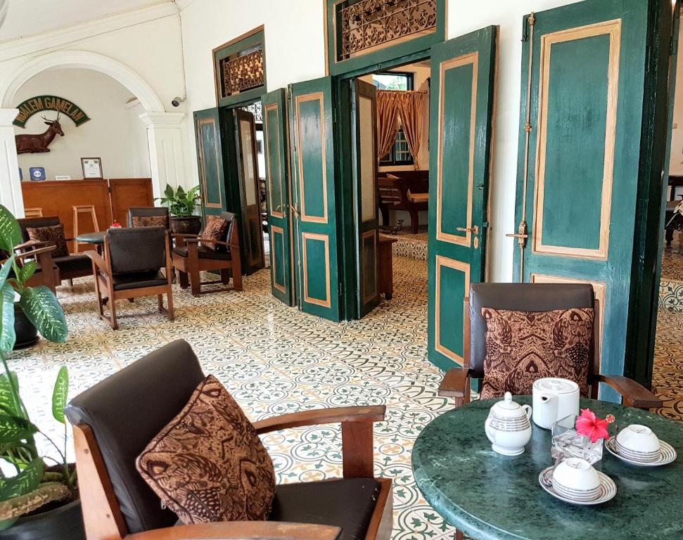 a living room with a table and chairs and a room at nDalem Gamelan in Yogyakarta