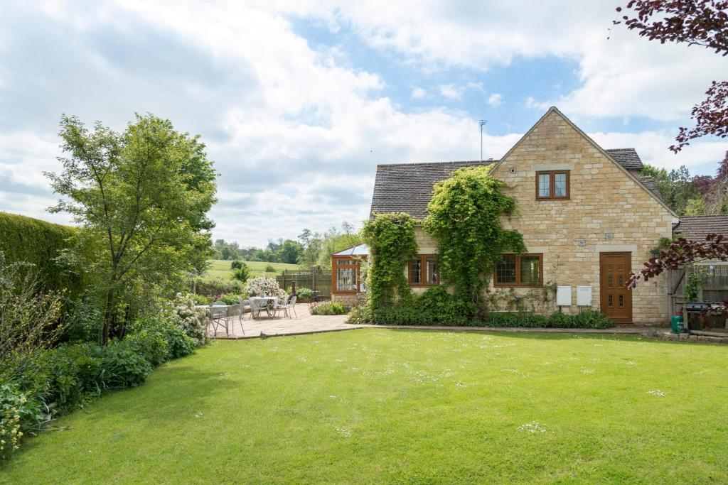 an exterior view of a house with a yard at Kingfisher Cottage in Winchcombe