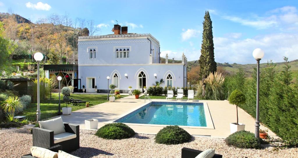 una casa con piscina frente a ella en Relais La Placa, en Francavilla di Sicilia
