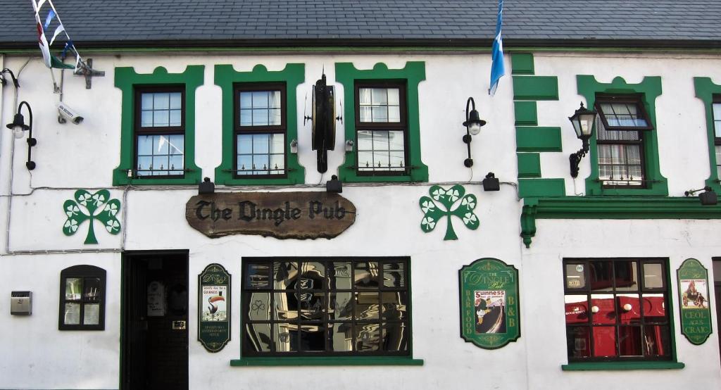 a white building with green and white windows at The Dingle Pub Rooms in Dingle