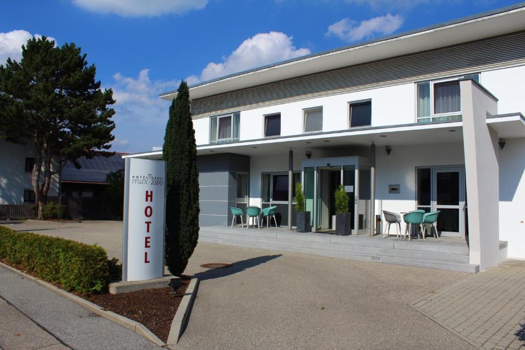 a white building with a sign in front of it at Hotel Garni Max Zwo in Dingolfing