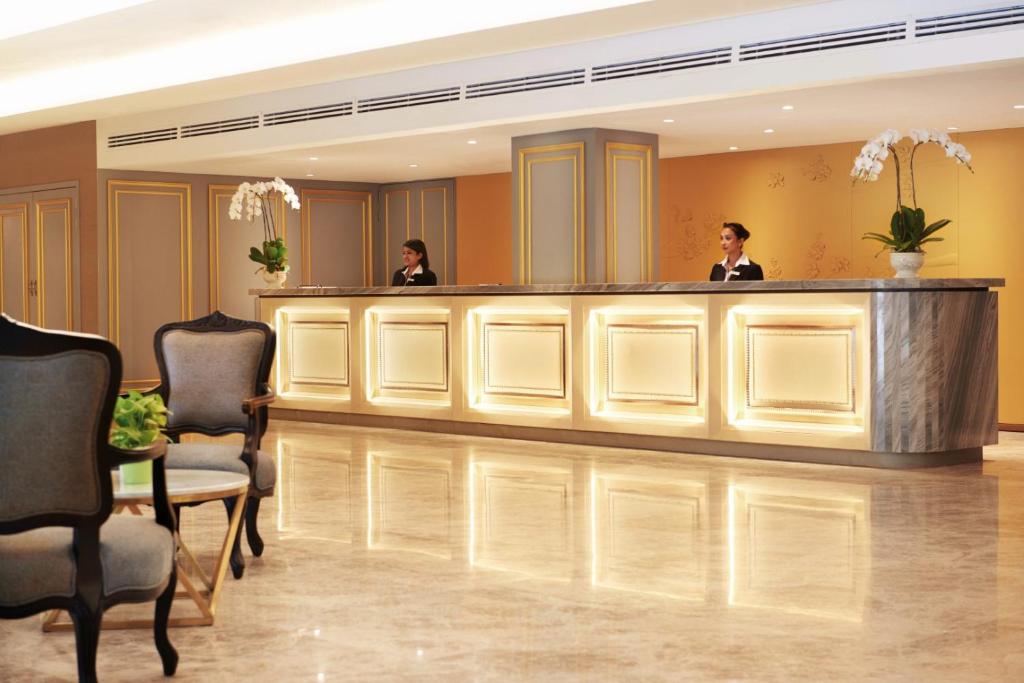 two people sitting at a bar in a hotel lobby at Cosmo Hotel Kuala Lumpur in Kuala Lumpur