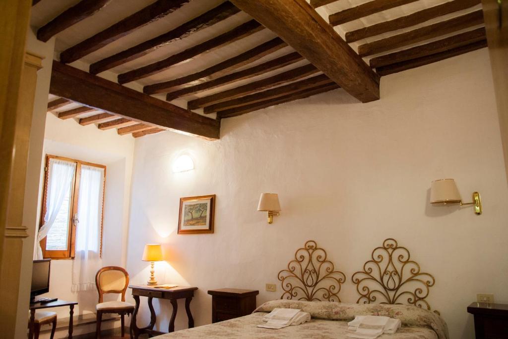 a bedroom with a bed and wooden ceilings at Locanda Il Pino in San Gimignano