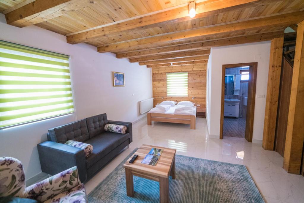 a living room with a couch and a table at Vila "Volujak" in Tjentište