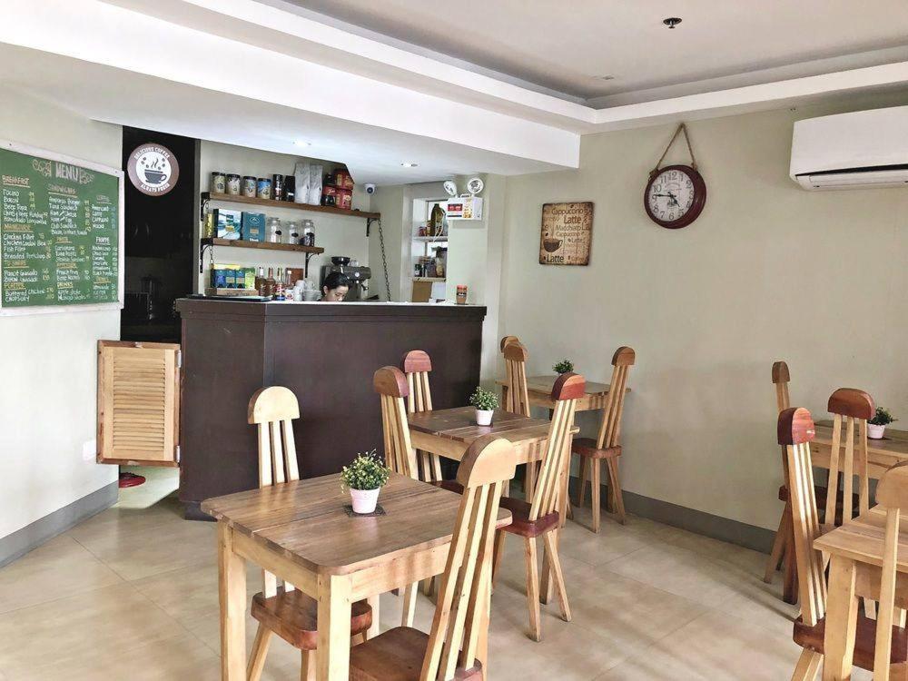 a restaurant with a table and chairs and a counter at Blue Paseo Grande Inn in Naga