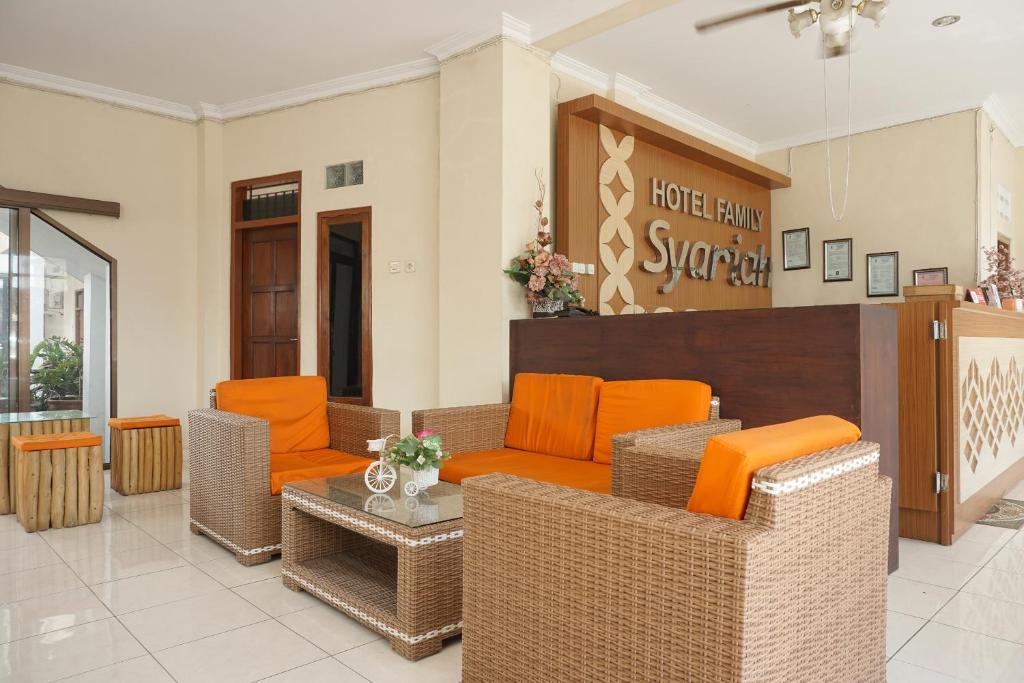 un vestíbulo de un hotel con sillas naranjas y una mesa en RedDoorz Plus @ Jalan Parangtritis 2, en Yogyakarta