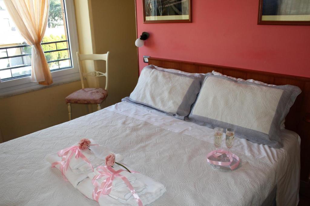 sypialnia z białym łóżkiem i czerwoną ścianą w obiekcie Affittacamere La Branda w mieście La Spezia